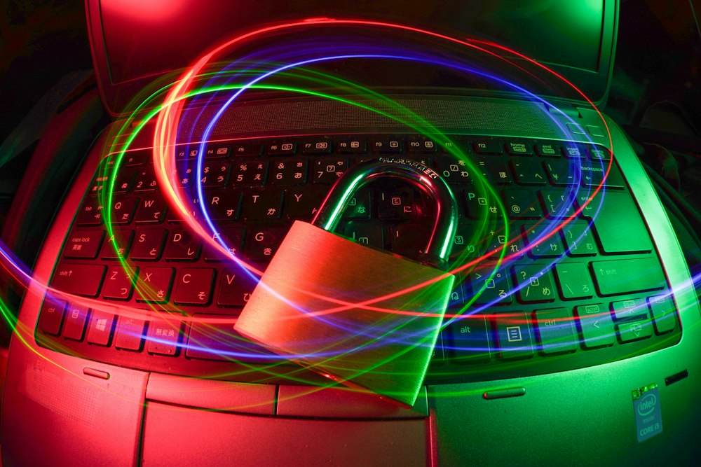 Padlock on a laptop keyboard, lit by network light trails
